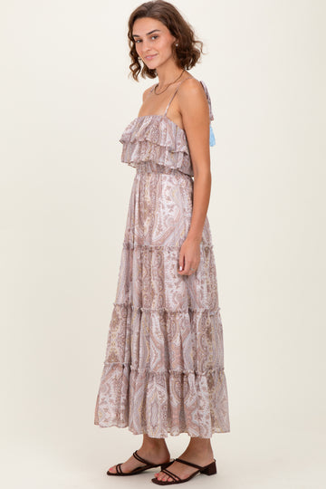 woman wearing a light purple tiered maxi dress with ruffles and adjustable straps, standing sideways against a neutral background
