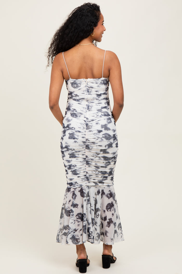 woman wearing a floral print maternity dress with a fitted bodice and flared skirt, showing off a baby bump from behind