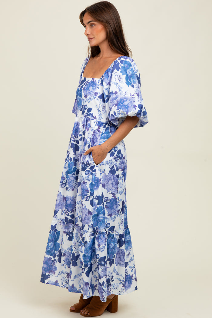 woman wearing a blue and white floral maxi dress with puff sleeves and pockets