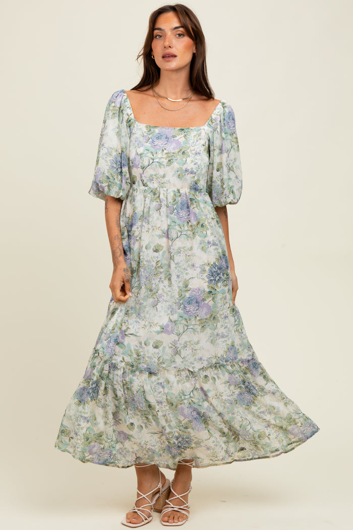 woman wearing a floral print maxi dress with puff sleeves and a square neckline