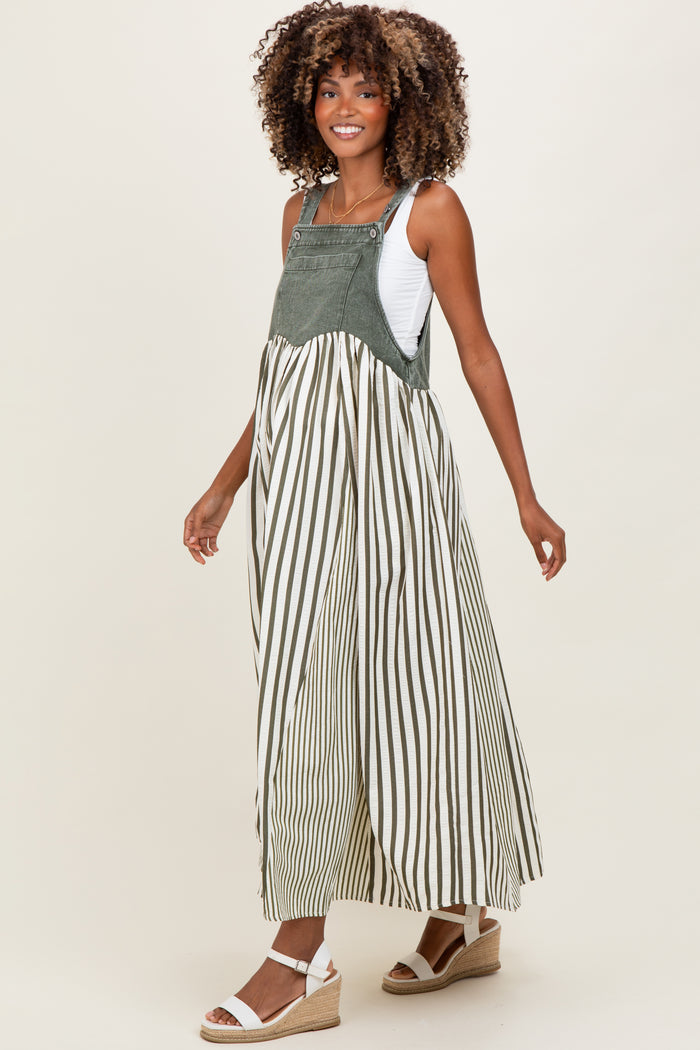 woman wearing a green and white striped maternity maxi dress with overalls, showcasing a visible baby bump