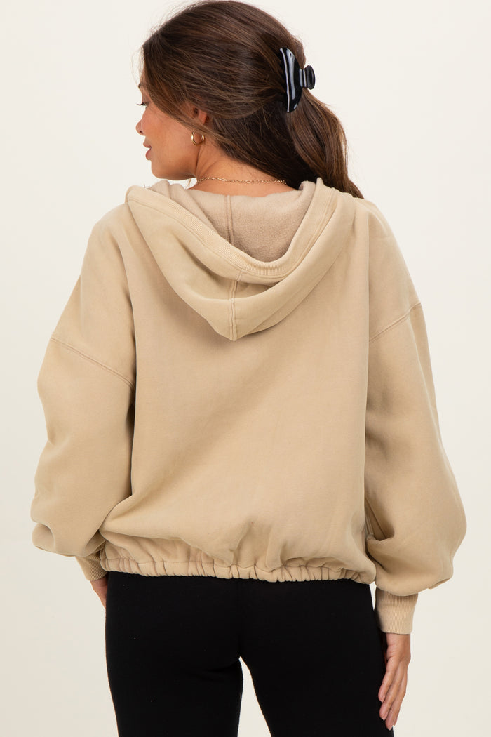 woman wearing a beige cropped maternity hoodie with a drawstring hem and hoodie detail
