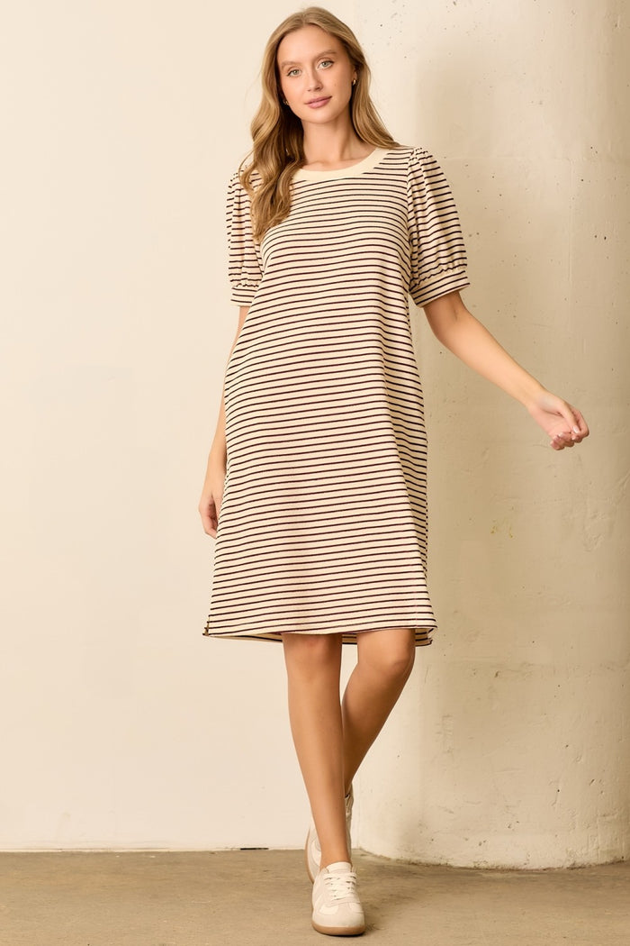 woman wearing a beige and brown striped short sleeve dress with puffed sleeves and a relaxed fit