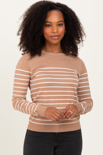woman wearing a tan striped long sleeve sweater with a fitted style and ribbed cuffs