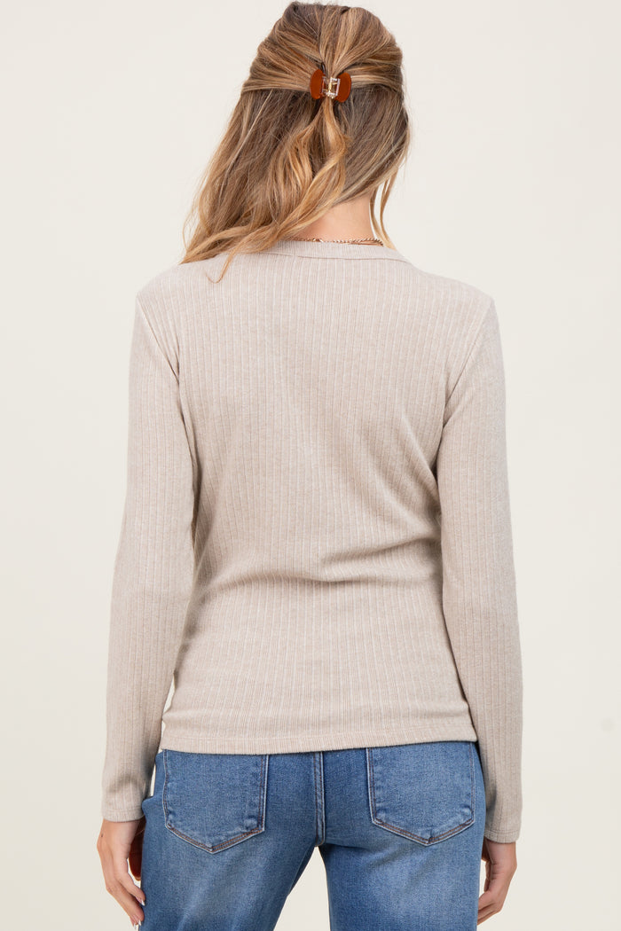woman wearing a beige ribbed maternity top, showing the back view with long sleeves and a slim fit