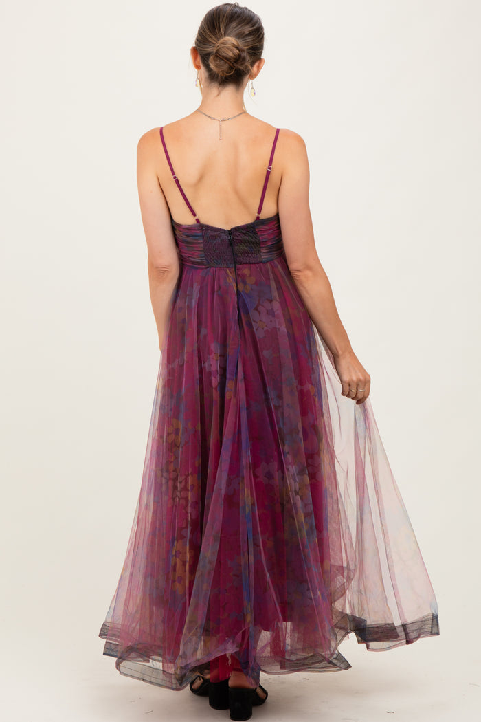 woman wearing a flowy purple floral maternity dress with adjustable straps and a fitted bodice, showing a baby bump