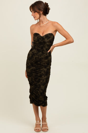 woman wearing a dark green strapless midi dress with ruching and a fitted silhouette