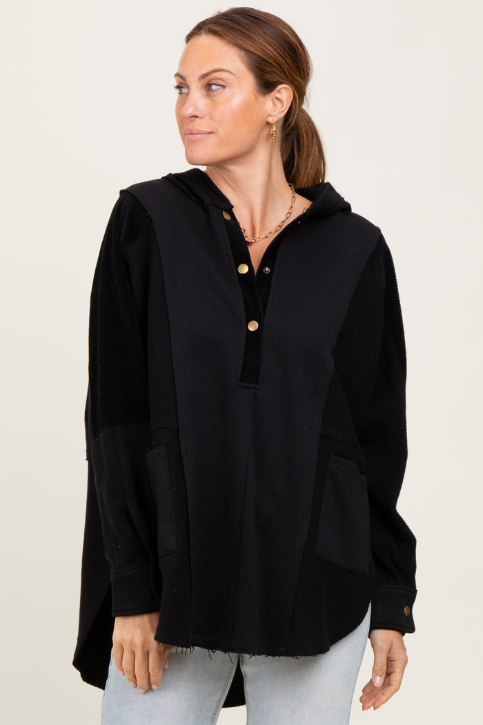 woman wearing a black oversized hoodie with a button-up neckline and front pockets