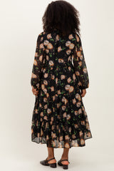 woman wearing a black floral long sleeve maxi dress with a tiered skirt and back button detail