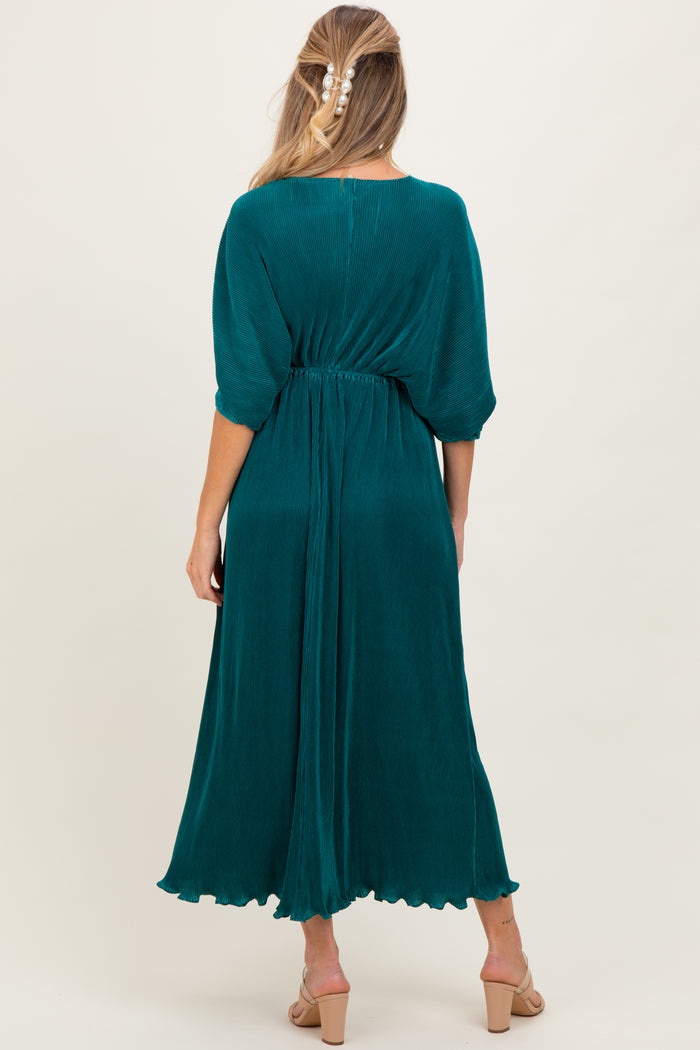 woman wearing a teal maternity dress with half sleeves and an elastic waist, showing a flowing silhouette from the back