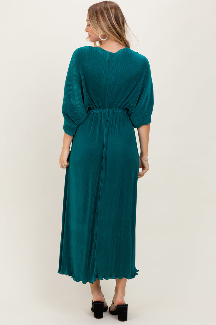 woman wearing a teal maxi dress with a cinched waist and balloon sleeves, seen from the back