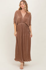woman wearing a brown pleated maxi dress with a deep v-neck and short sleeves.