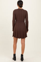 woman wearing a brown ribbed long sleeve dress with a flared hem and back detail