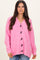 woman wearing a bright pink oversized cardigan with large black buttons and a v-neckline