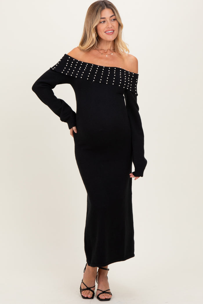 woman wearing a black off-the-shoulder maternity dress with studded details and a visible baby bump