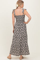 woman wearing a gray floral maxi dress with smocked back and bow tie straps
