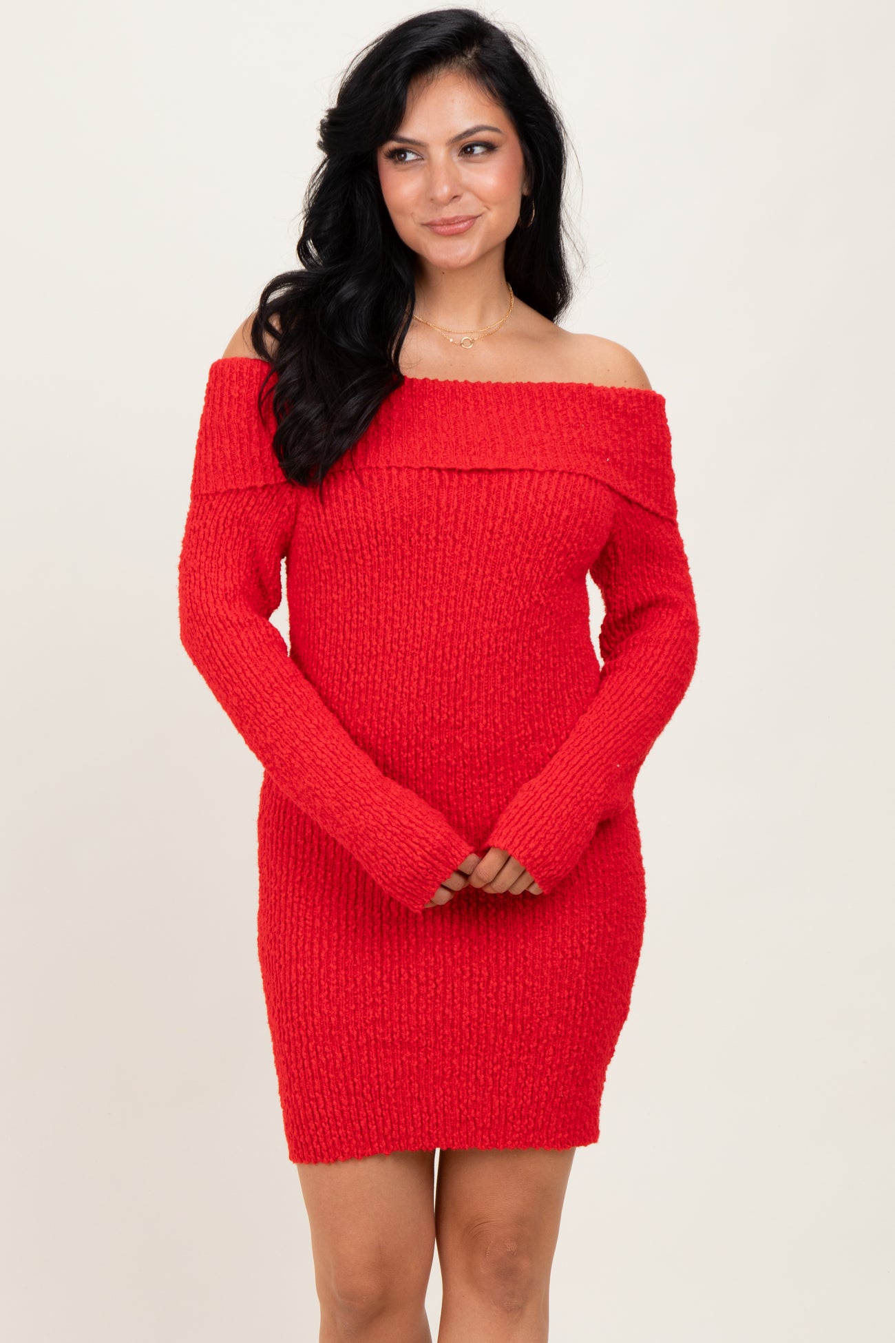 woman wearing a red off-the-shoulder sweater dress with a ribbed texture and long sleeves