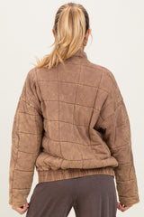 woman wearing a brown quilted maternity jacket with a relaxed fit and elastic hem, seen from the back