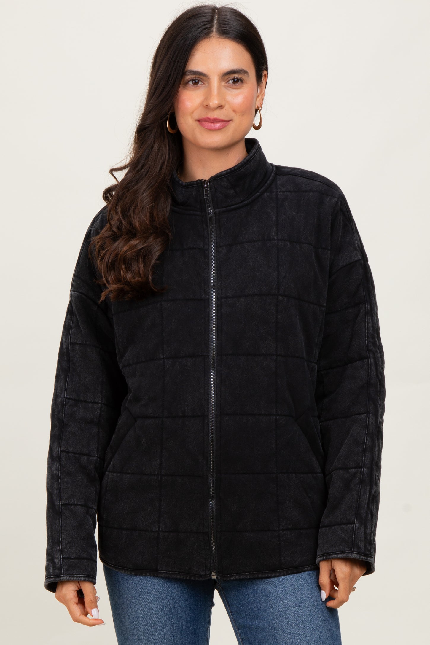 woman wearing a black quilted zip-up jacket with a high collar and long sleeves