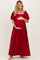 woman wearing a red maternity maxi dress with puff sleeves and holding her baby bump
