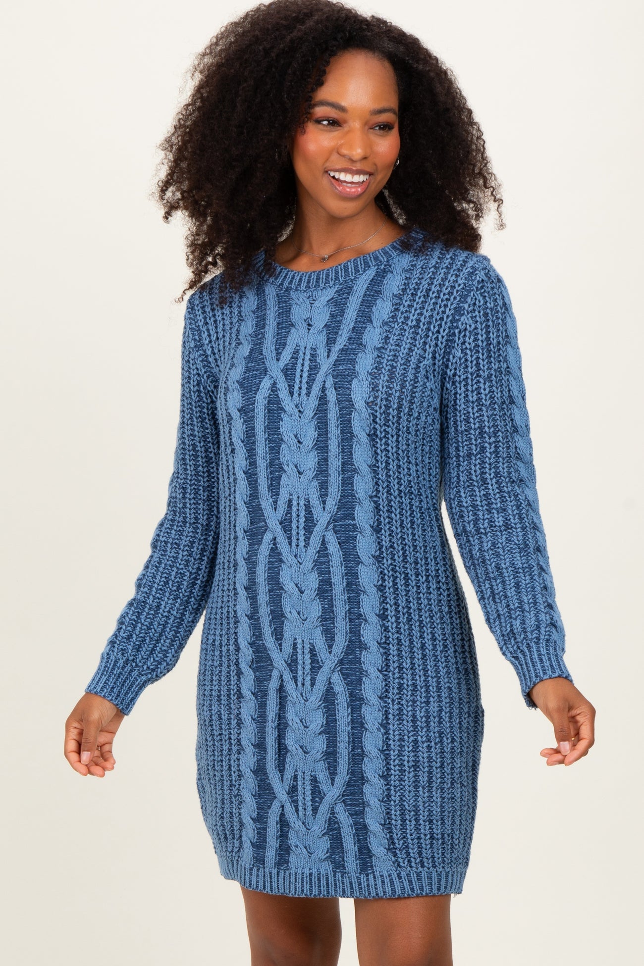 woman wearing a blue cable knit sweater dress with long sleeves and a ribbed texture