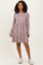 woman wearing a mauve long sleeve tiered dress with a ribbed texture and white sneakers