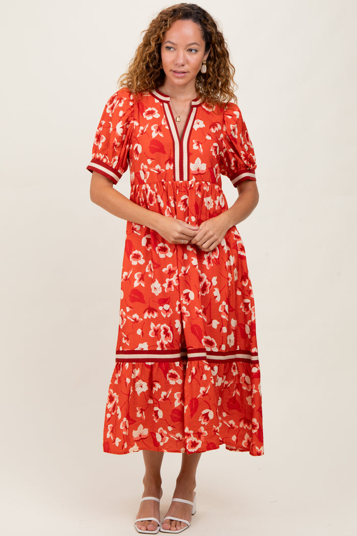 woman wearing a red floral midi dress with puff sleeves and a tiered skirt