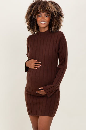 woman wearing a chocolate brown ribbed maternity dress with long sleeves and holding her baby bump