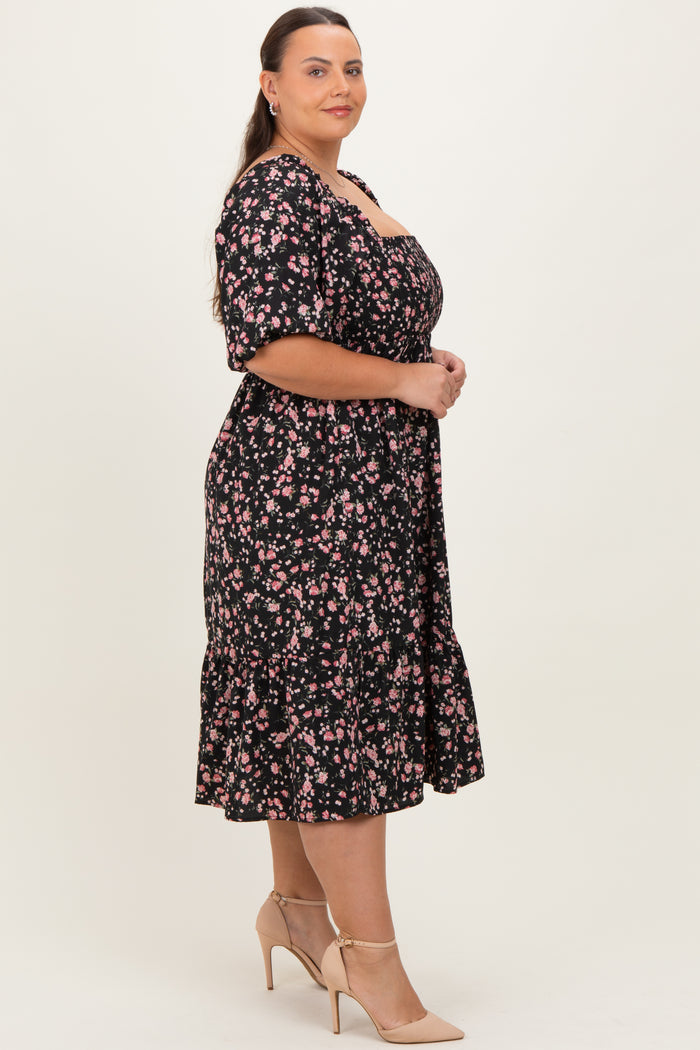 woman wearing a black floral plus-size midi dress with short sleeves and a ruffled hem