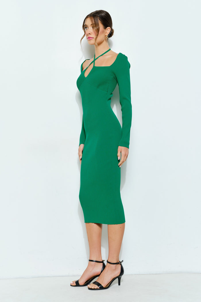 woman wearing a fitted green ribbed midi dress with long sleeves and a crisscross neckline detail