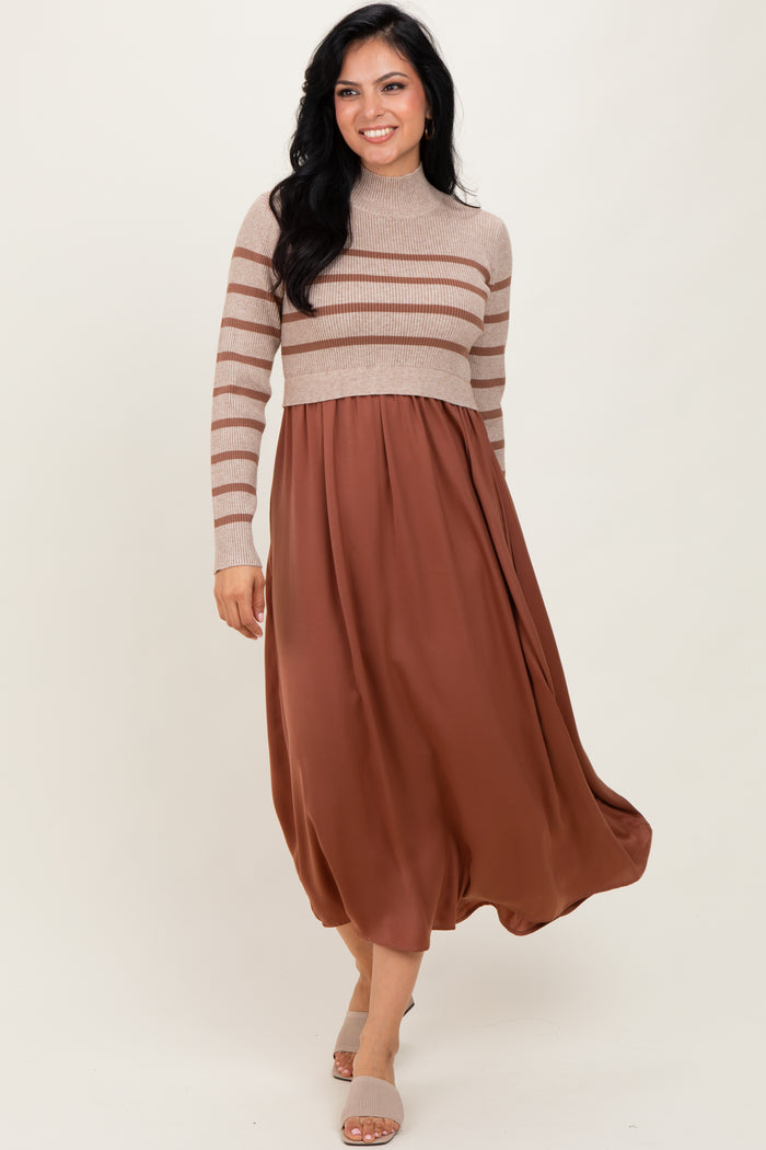 woman wearing a beige striped long sleeve sweater dress with a brown flowy skirt
