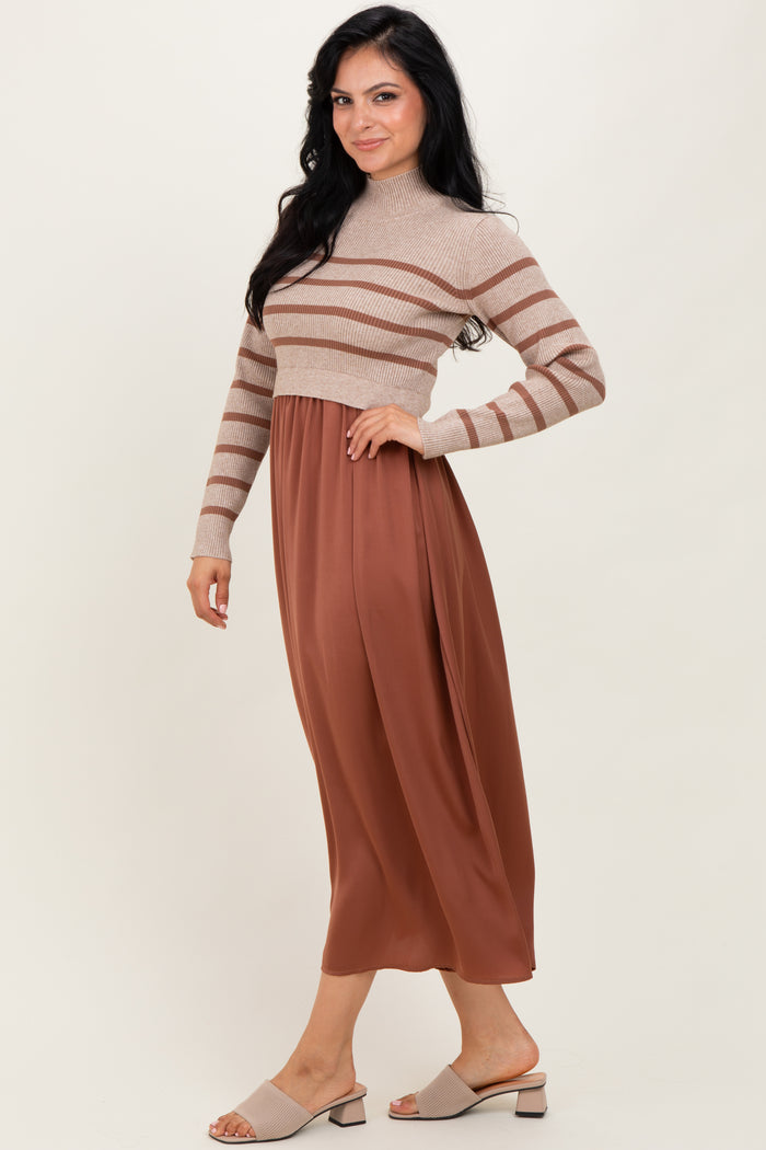 woman wearing a beige striped sweater cropped top and a brown midi skirt, posing with one hand on her hip