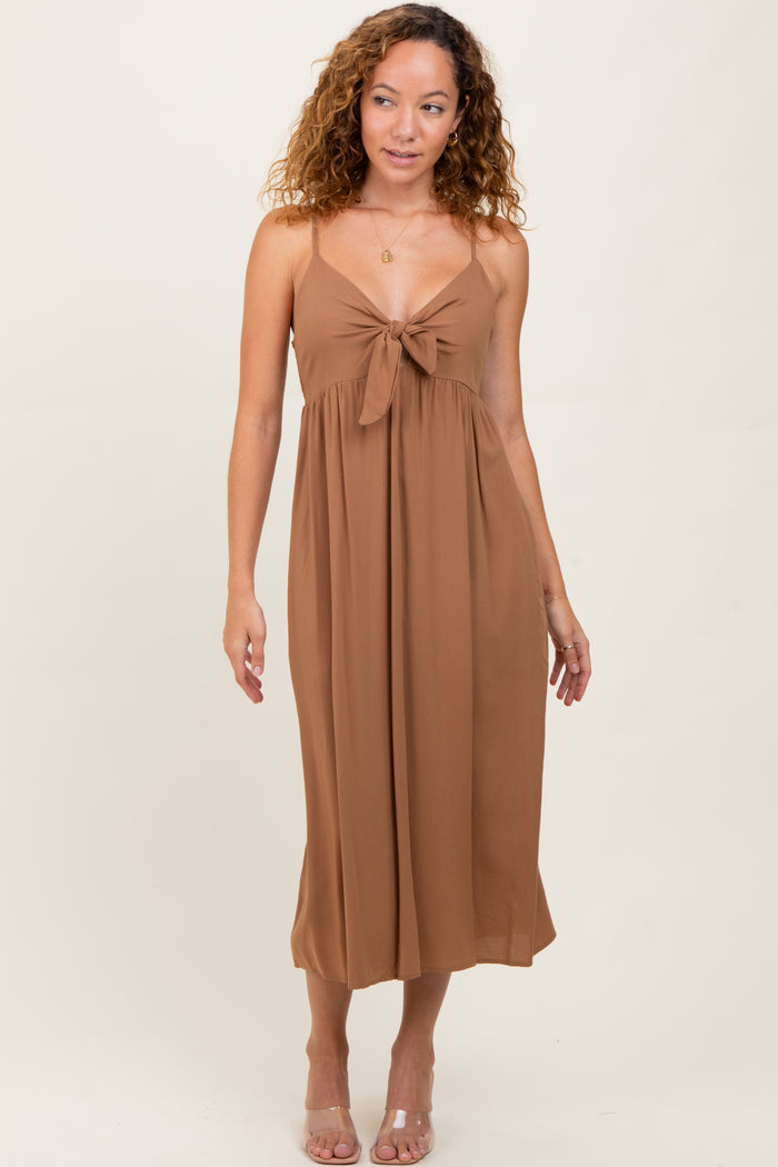 woman wearing a brown midi dress with a knotted front detail and spaghetti straps