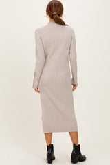 woman wearing a beige ribbed knit long sleeve dress with buttons on the sleeves and ankle-length cut