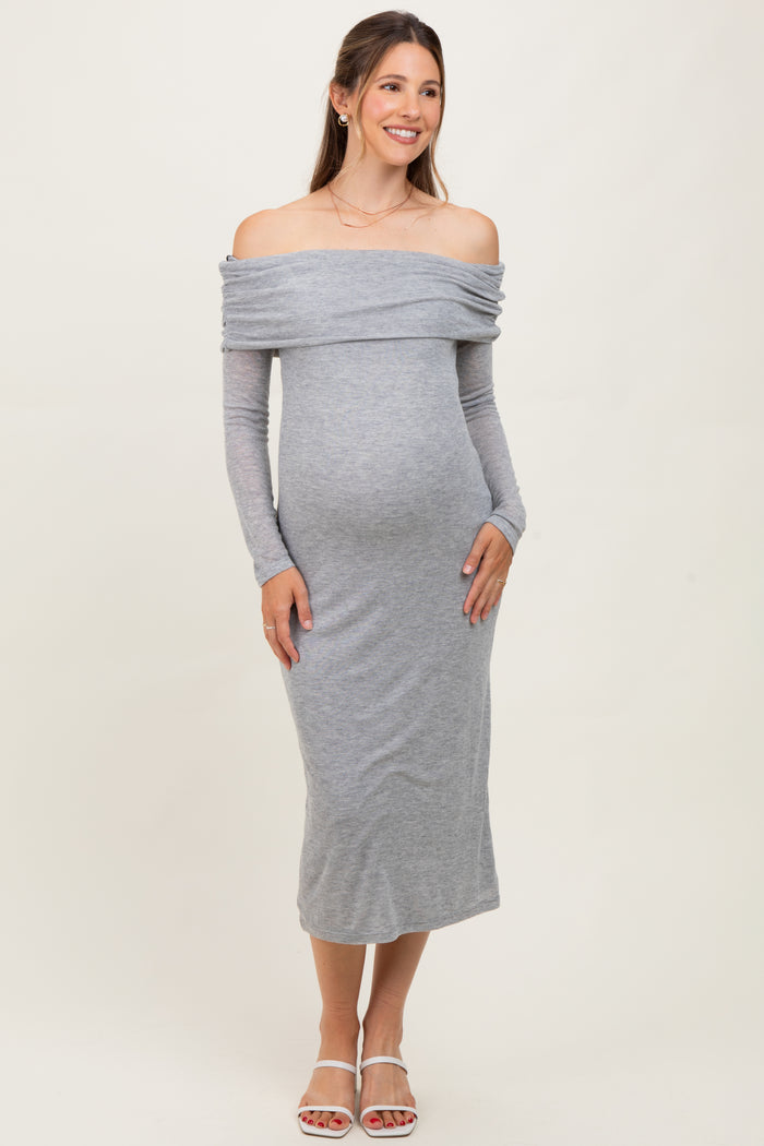 woman wearing a grey off-shoulder maternity dress with long sleeves and a visible baby bump