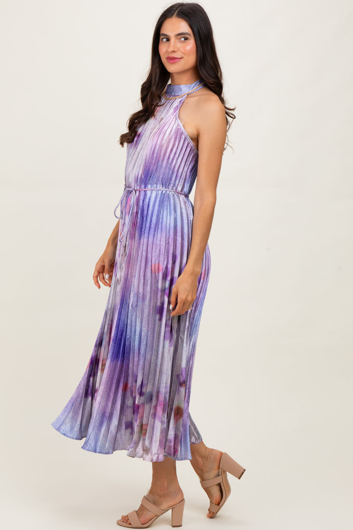 woman wearing a sleeveless purple and blue tie-dye maxi dress with a halter neck and a flowy skirt