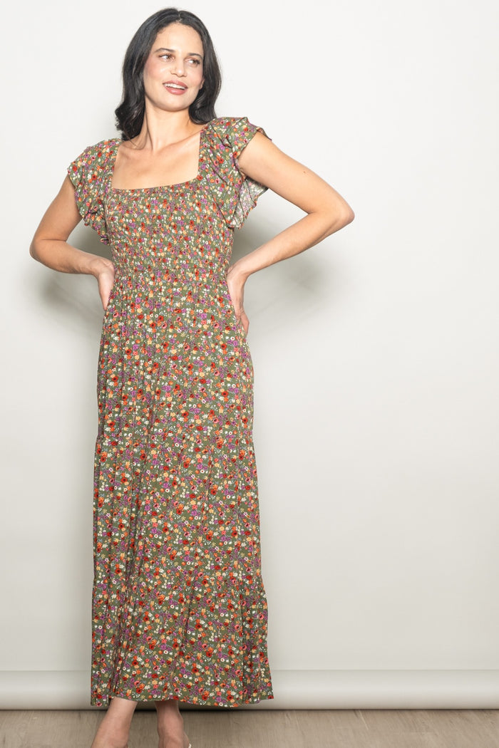 woman wearing a floral print maxi dress with flutter sleeves and a square neckline