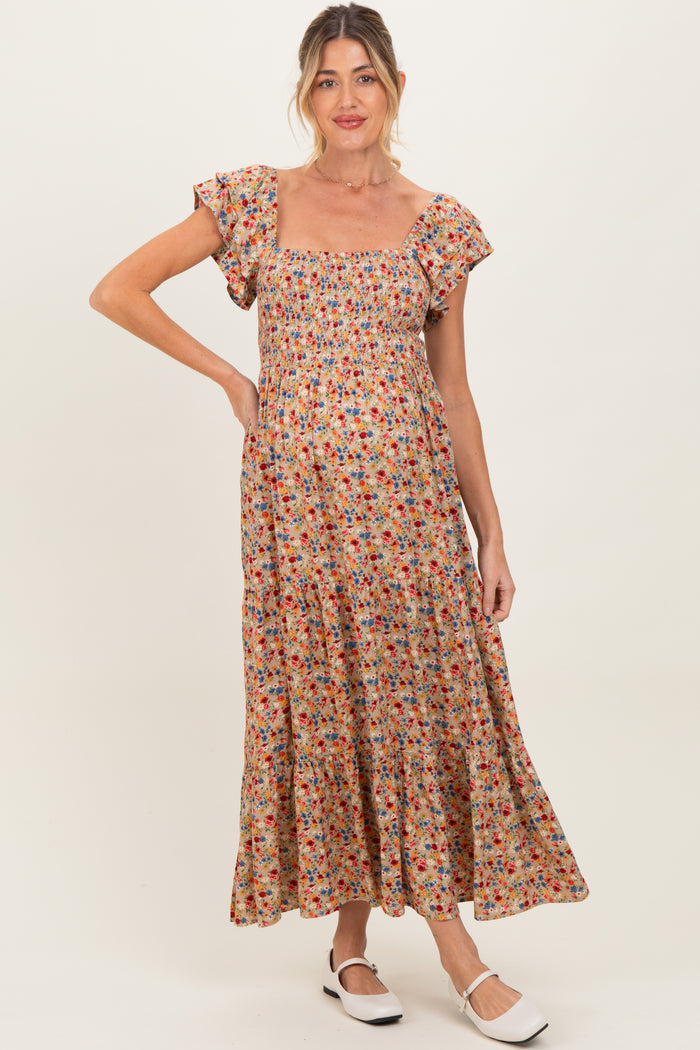 woman wearing a floral print maternity maxi dress with short puff sleeves and a square neckline, showing her baby bump