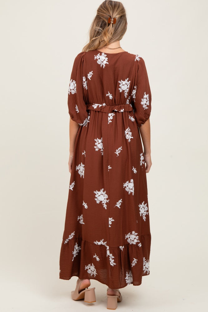woman wearing a brown floral maxi dress with puff sleeves and a belted waist, showcasing a beautiful maternity style