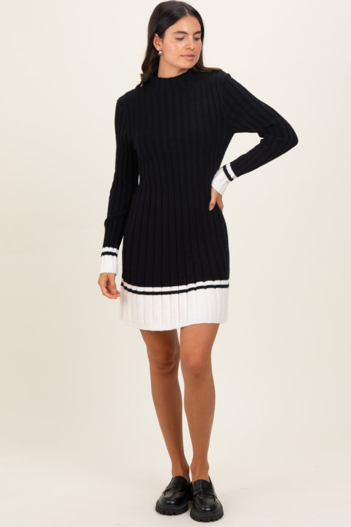 woman wearing a black ribbed sweater dress with white stripe details and long sleeves