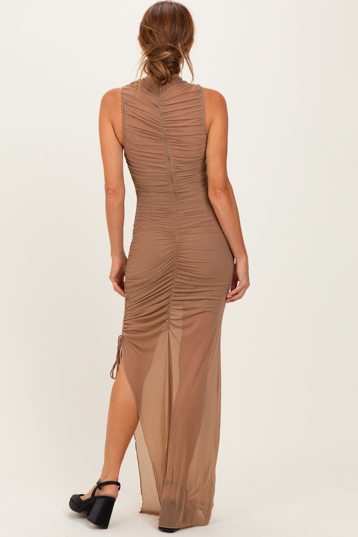 woman wearing a beige sleeveless maxi dress with ruching details and a side slit, shown from the back