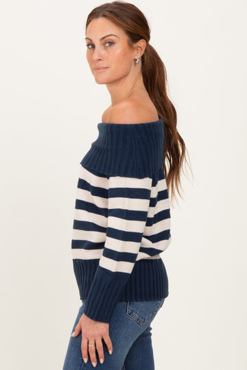 woman wearing a navy and cream striped off-the-shoulder sweater with ribbed hem and fitted silhouette