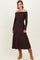 woman wearing a brown off-the-shoulder knit maxi dress and tan knee-high boots
