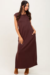woman wearing a sleeveless brown maxi dress with side pockets and a relaxed fit