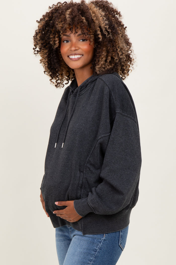woman wearing a dark gray maternity hoodie with a relaxed fit and holding her baby bump