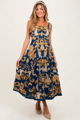 woman wearing a navy blue maternity dress with floral gold patterns and thin straps, showing her baby bump
