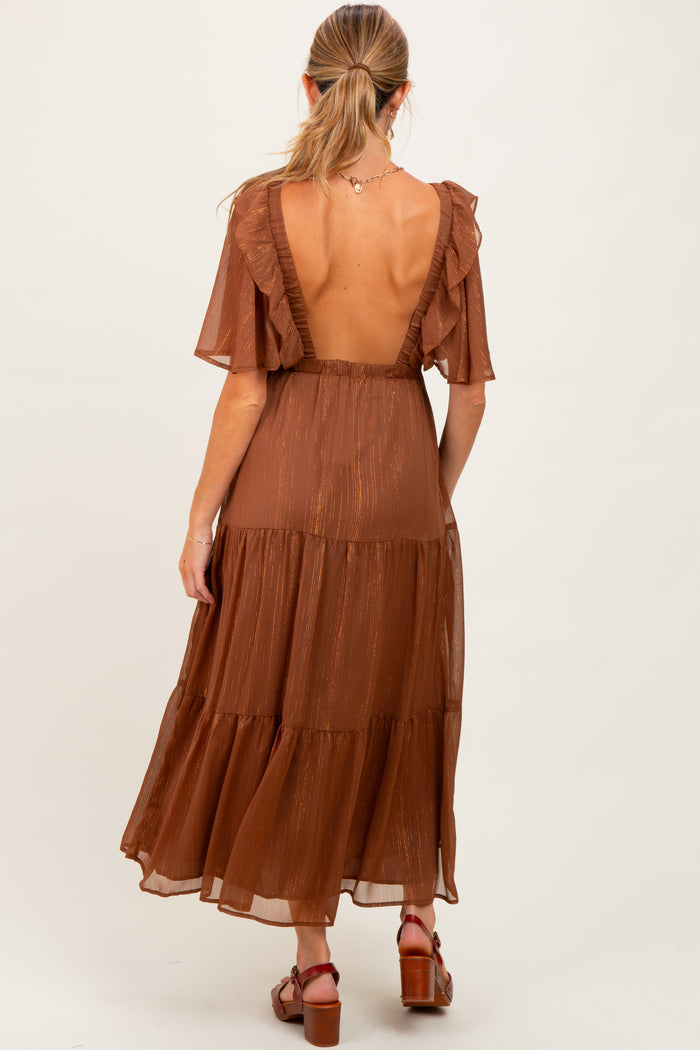 woman wearing a rust-colored maternity dress with flutter sleeves and a tiered design, showing her back