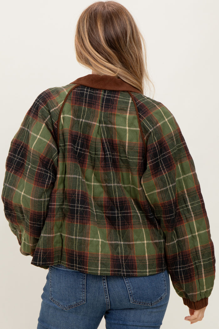 woman wearing a green and brown plaid oversized jacket with a brown collar and back view visible