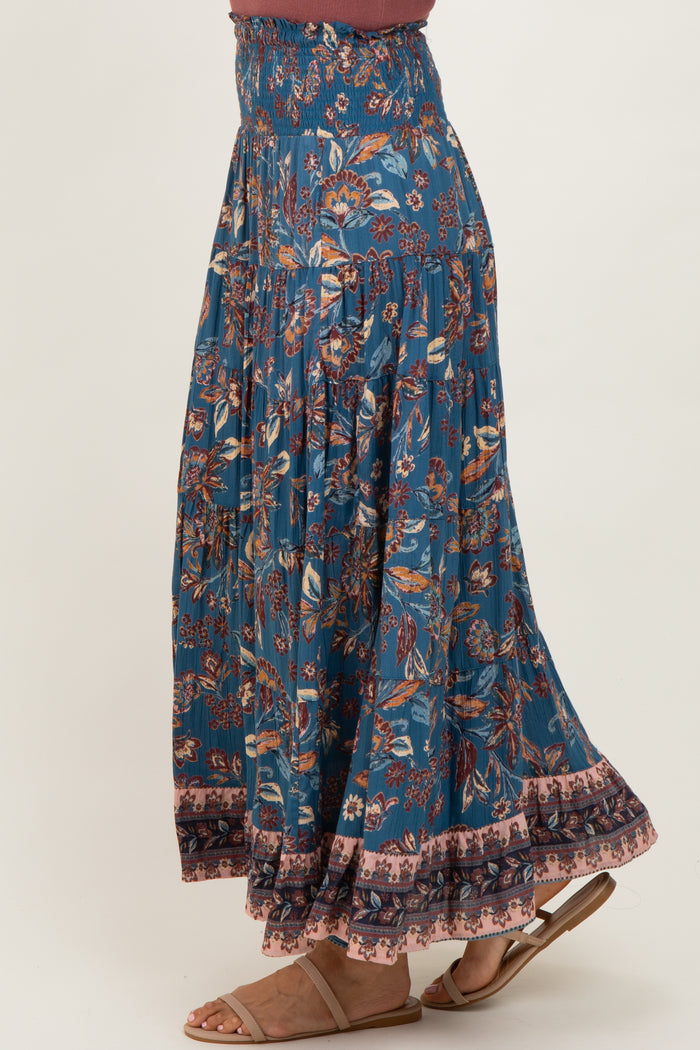 woman wearing a blue floral maxi skirt with elastic waistband and ruffle hem
