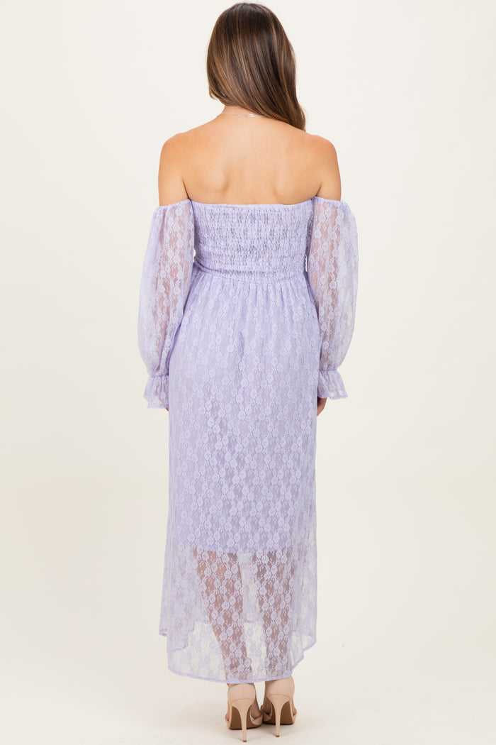 woman wearing a lavender off-the-shoulder maternity dress with lace details and long puff sleeves, showing her back